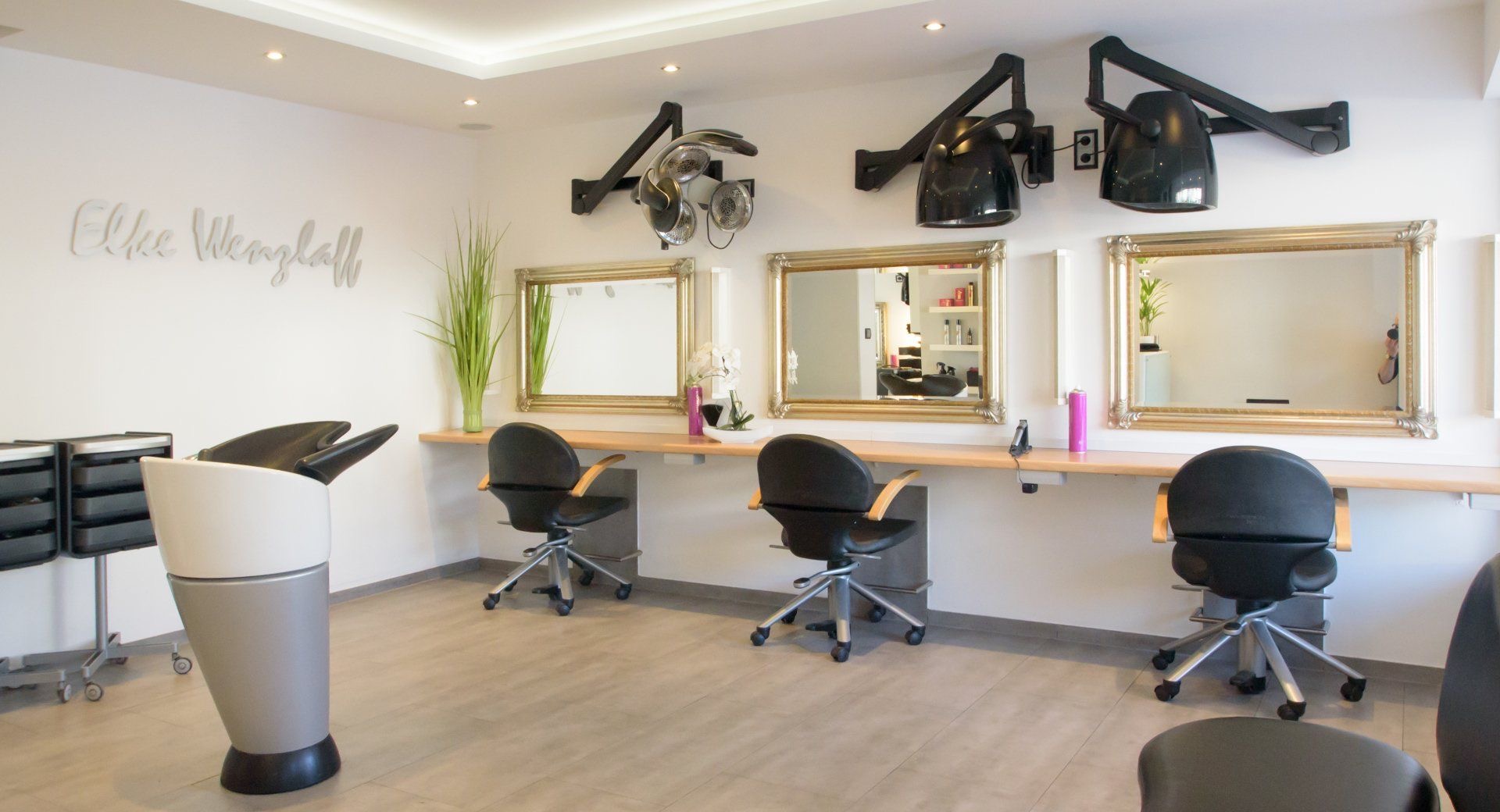 Heller Salon mit goldgerahmten Spiegeln in der Carl-Goerdeler-Straße